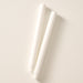 Two natural white colored pillar candles with ribbed bases, laying flat on a white background.