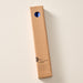 A tall, narrow cardboard box with a circular window display cutout at the top showing two cobalt blue candles inside, photographed on a clean off-white background. The box has printed text near the bottom including the brand name 'Ten Thousand Villages'.