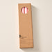 A tall, narrow cardboard box with a circular window display cutout at the top showing two ginger colored candles inside, photographed on a clean off-white background. The box has printed text near the bottom including the brand name 'Ten Thousand Villages'.
